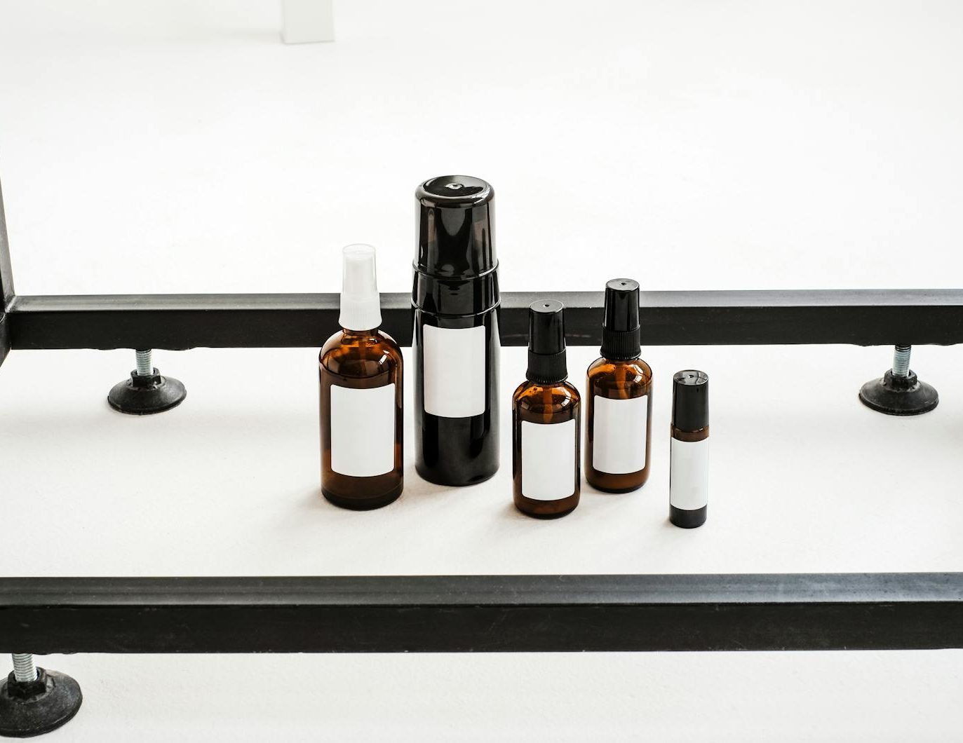A minimalist still life photography of various aromatherapy bottles on a white table.